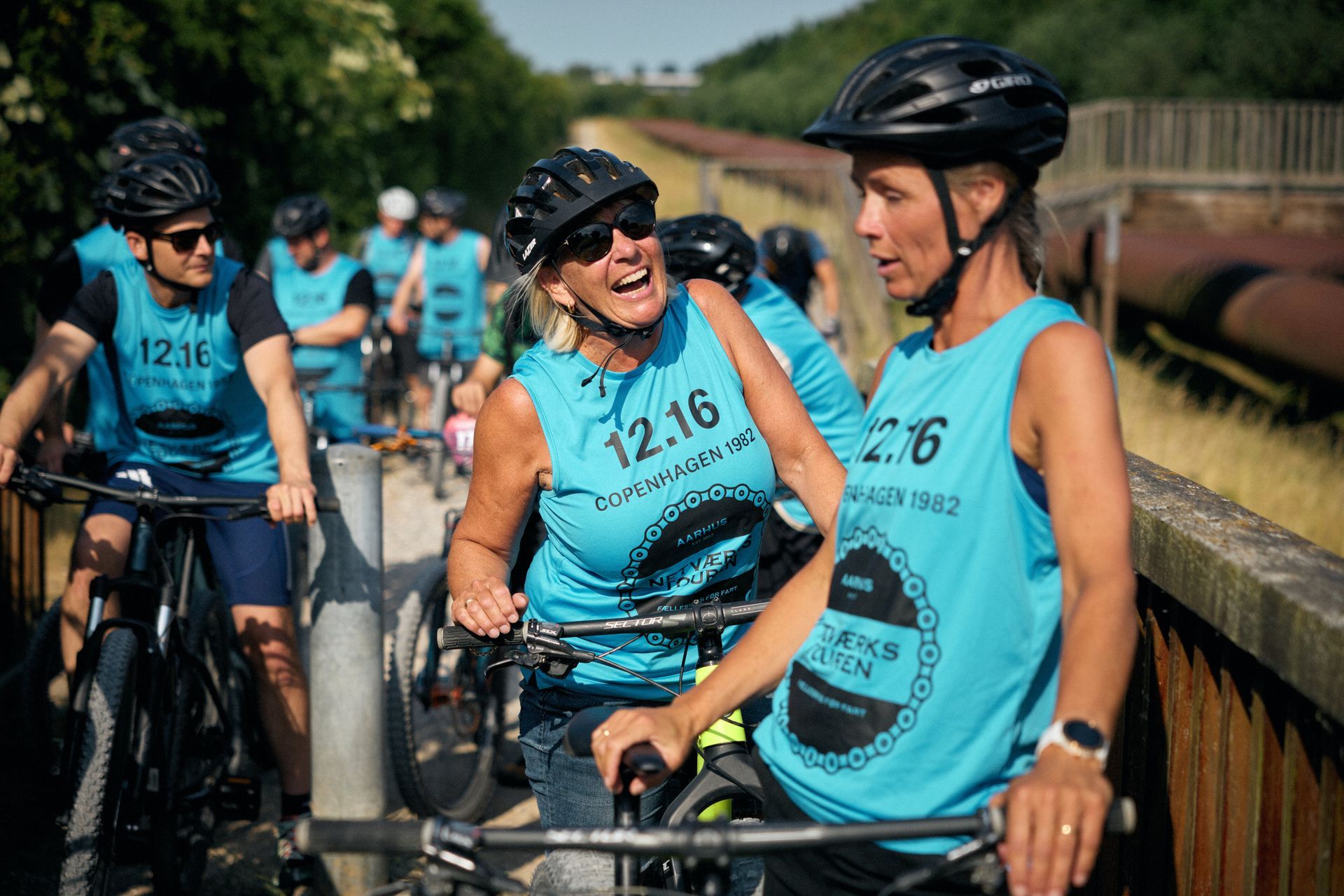 En gruppe mennesker cykler på en sti.