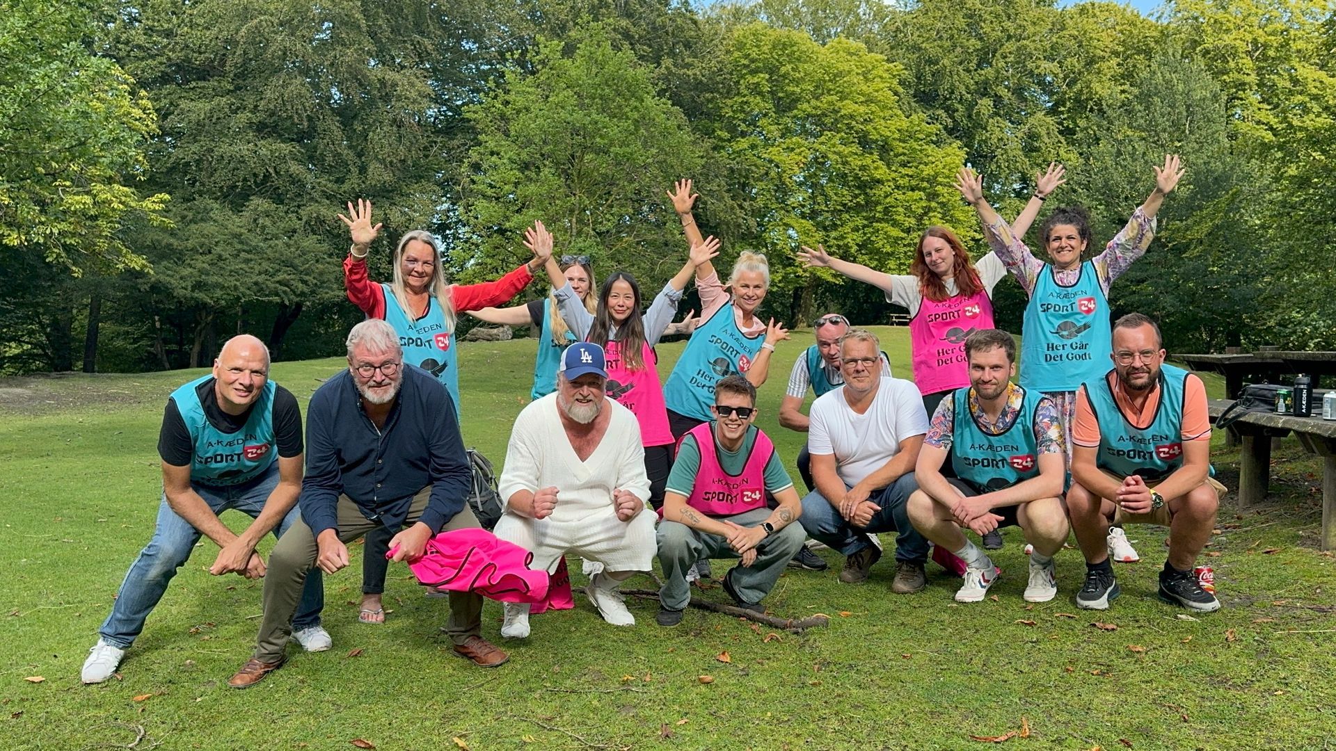 En gruppe mennesker poserer til et billede i en park.