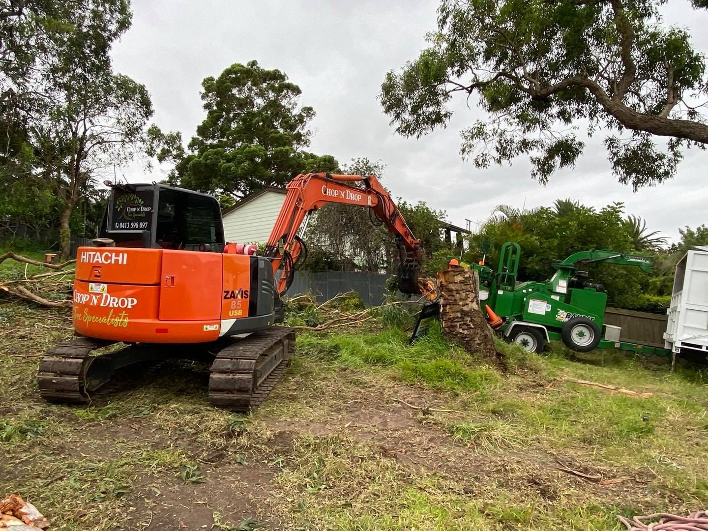 Orange Excavator Removing Tree Stump — Chop n Drop Tree Specialists in Valentine, NSW