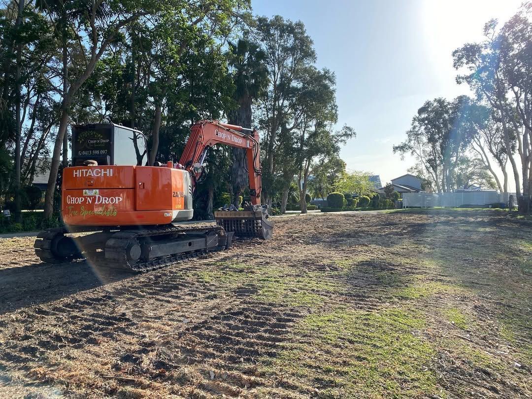 Orange Excavator on a Cleared Construction Site — Chop n Drop Tree Specialists in Belmont, NSW