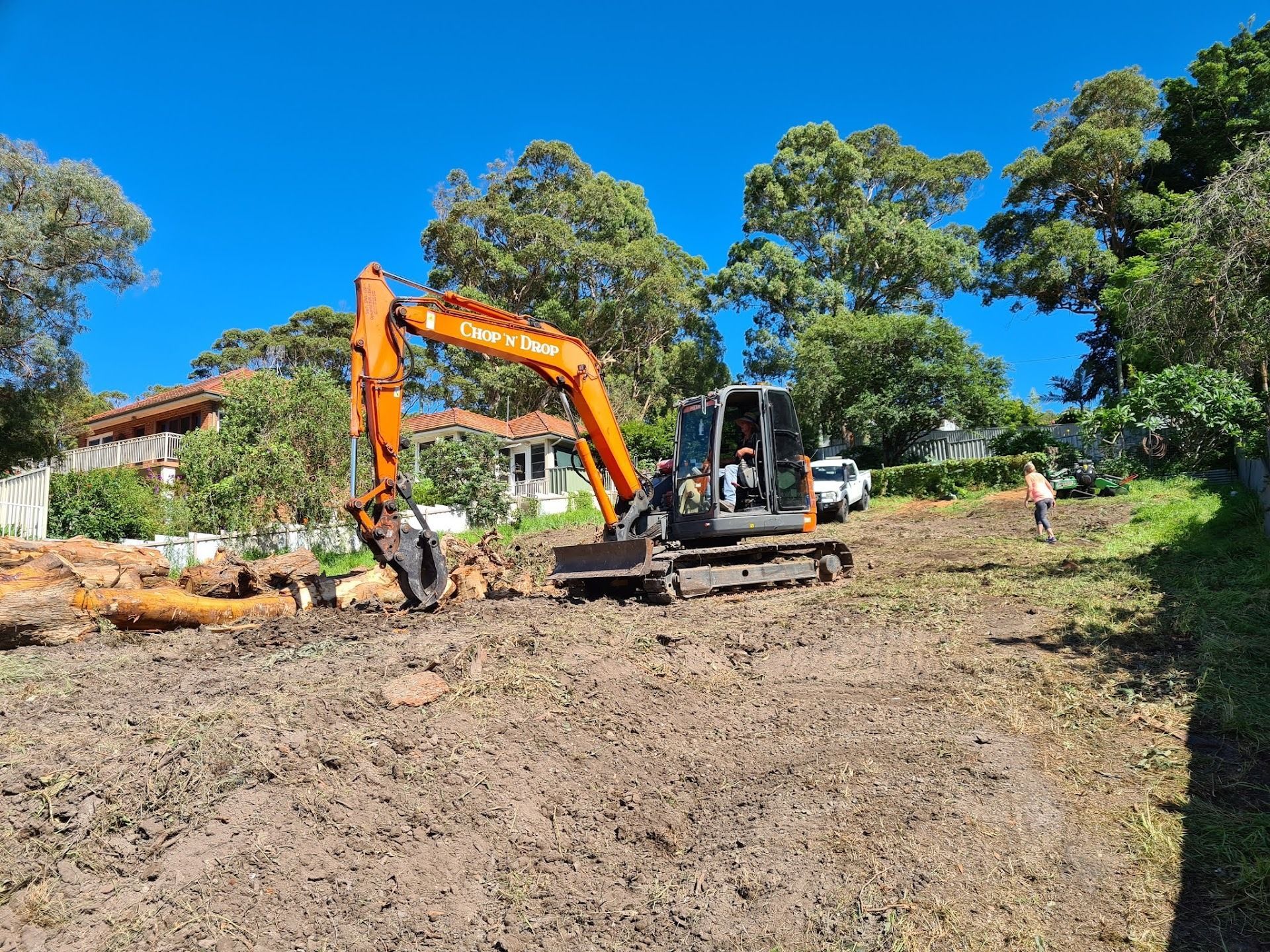 An Excavator on a Muddy Hillside — Chop n Drop Tree Specialists in Belmont, NSW