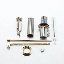 Chrome bathroom sink drain parts laid out on a white surface.