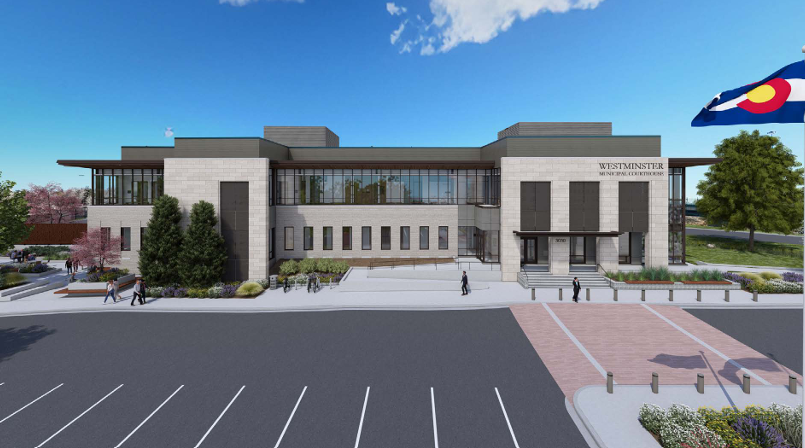 Modern building with Colorado flag and landscaping. People walk toward the entrance.
