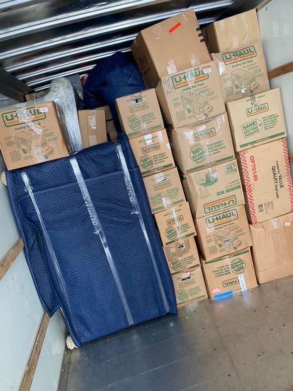 Cardboard boxes and moving blankets packed inside a moving truck.