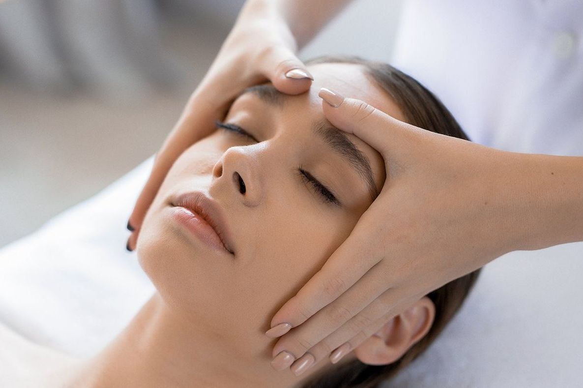 Une femme reçoit un massage du visage dans un spa.