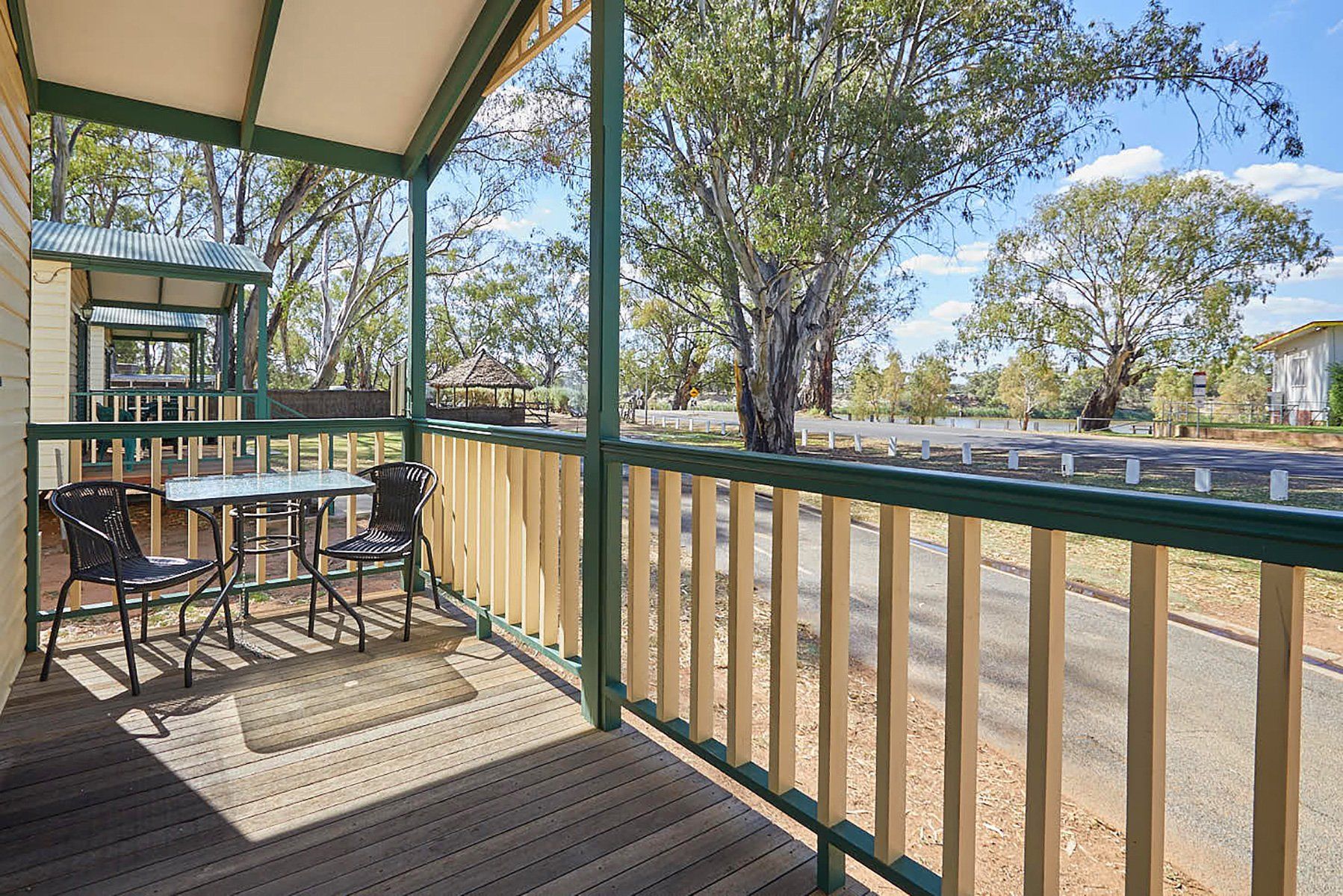 Apex Riverbeach Holiday Park cabin's with a front deck overlooking river beach and trees in the background .