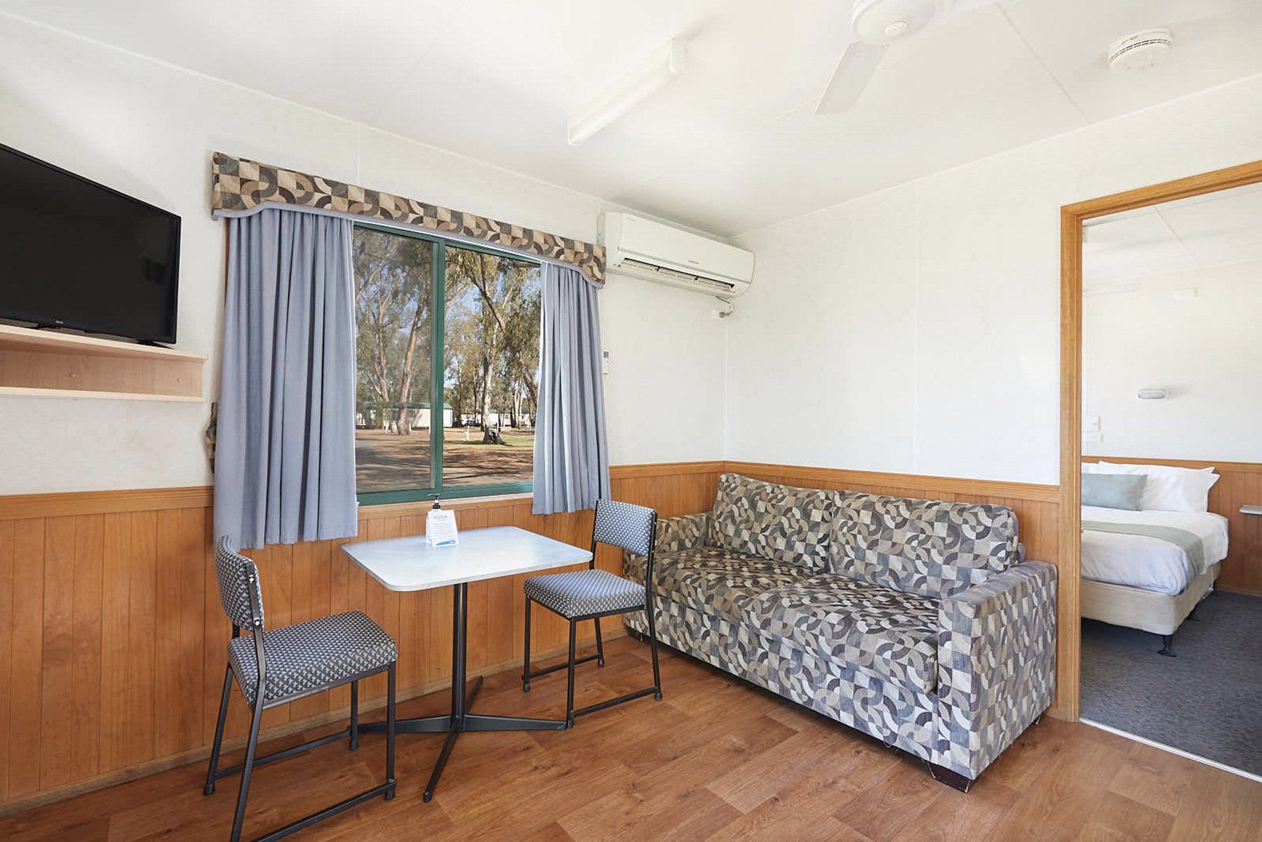 Apex Riverbeach Holiday Park cabin with a couch , air conditioner , table and chairs .