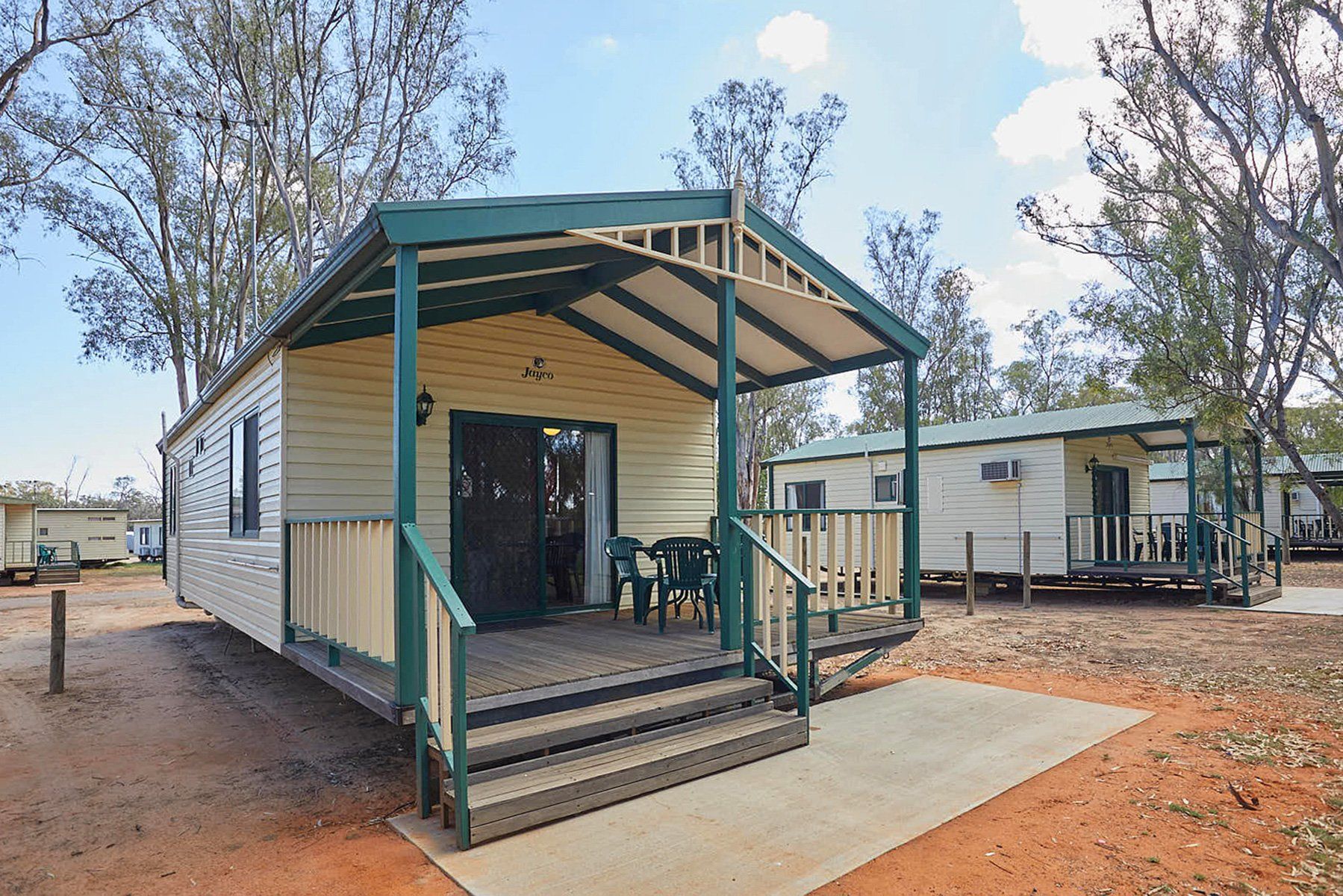 Apex Riverbeach Holiday Park cabin with beds , couch , table and chairs , kitchen , ensuite bathroom , outdoor dining , deck , television , fans