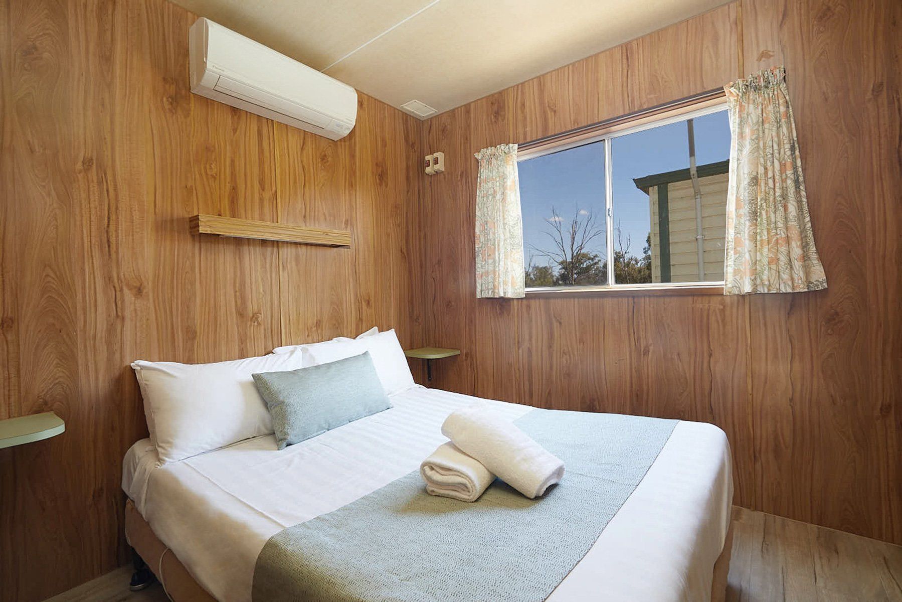 Apex Riverbeach Holiday Park cabin's bedroom with air conditioner