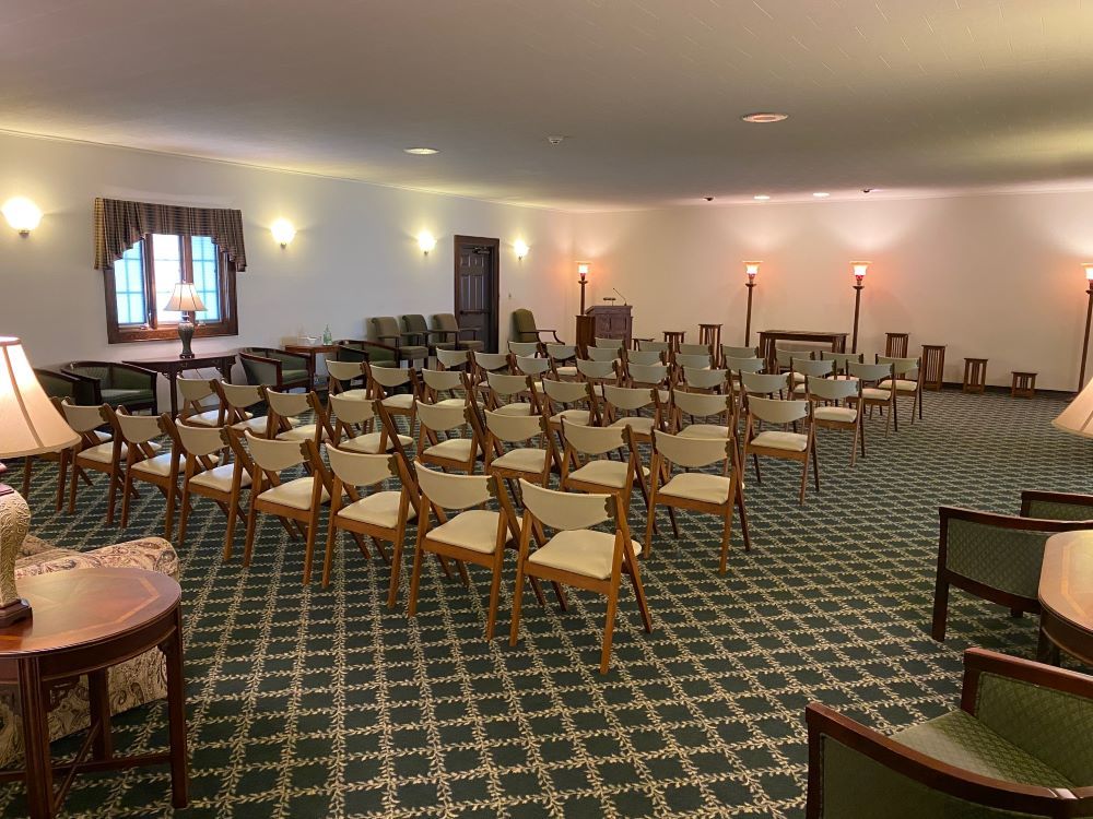 A large room filled with rows of chairs and lamps.