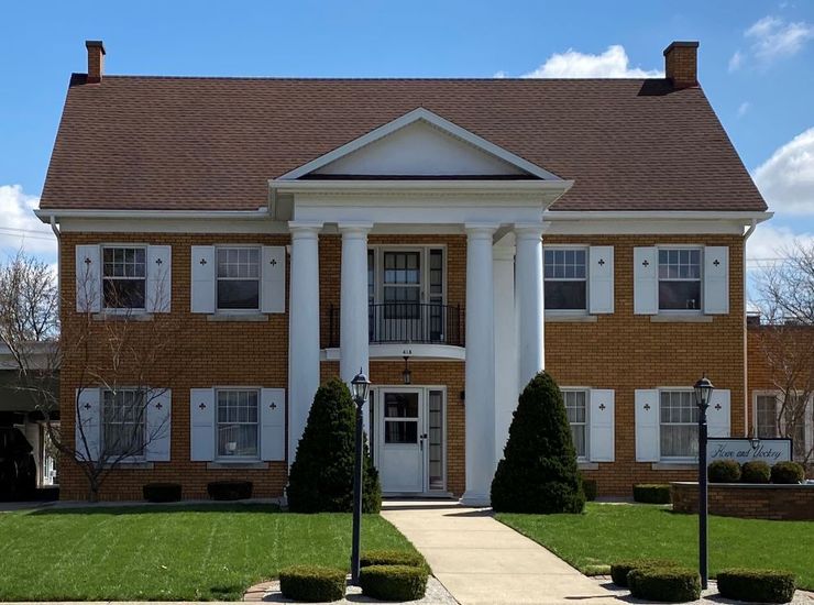 A large brick house with white shutters on the windows