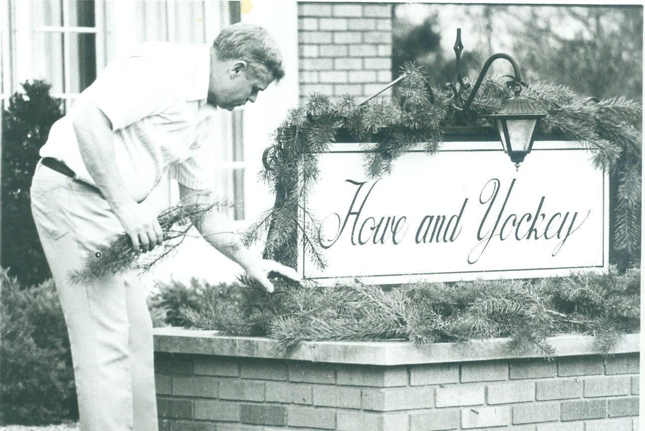 A man is standing in front of a sign that says home and jockey