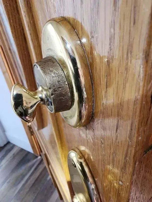 A close up of a door knob on a wooden door.