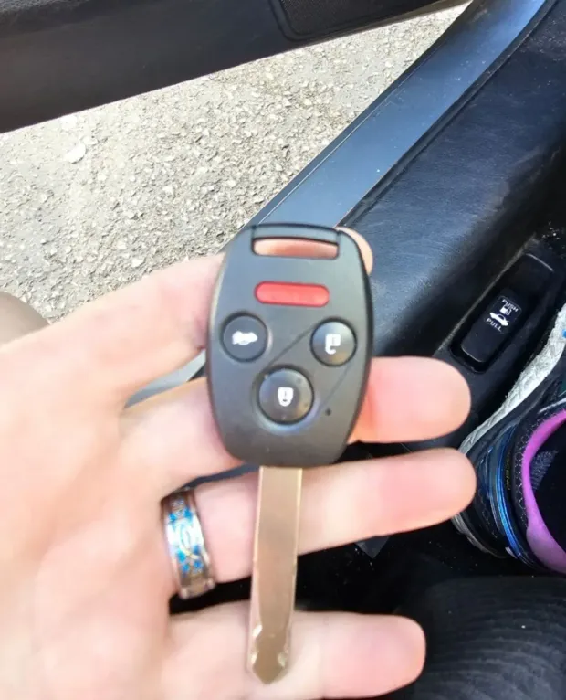 A person is holding a car key in their hand