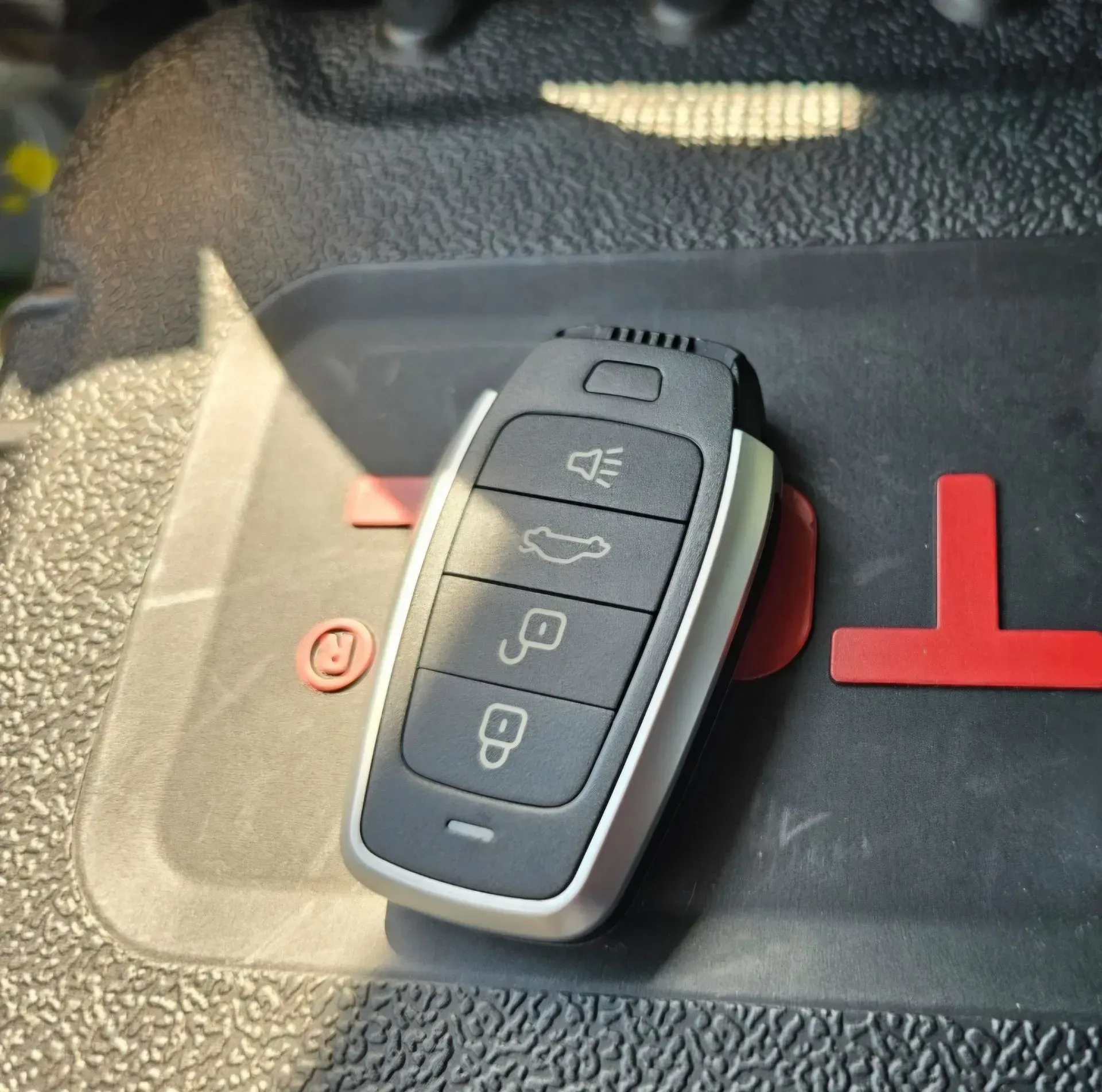 A car key sitting on top of a toyota logo