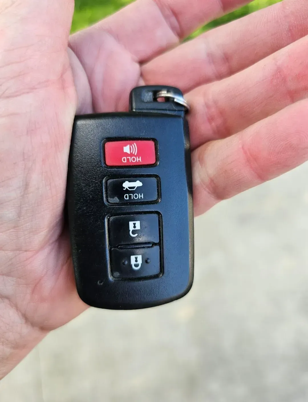 A person is holding a car key in their hand.