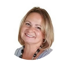 Woman with blonde hair smiling, wearing a necklace and hoop earring.