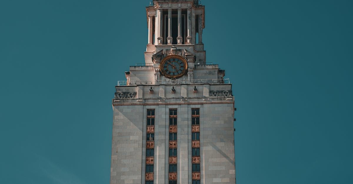 A tall building with a clock on top of it against a blue sky.