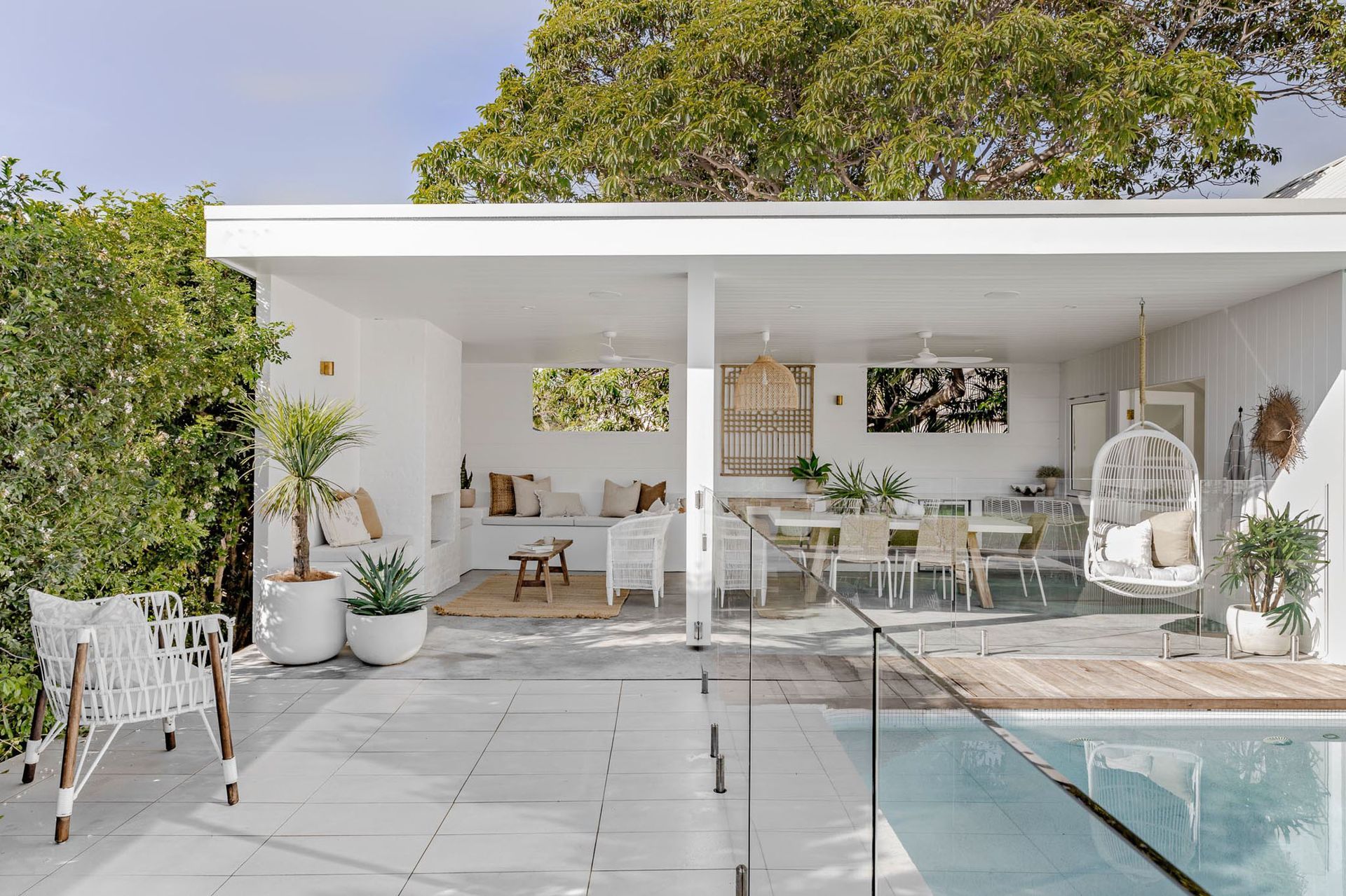 There is a swimming pool in the backyard of a house.