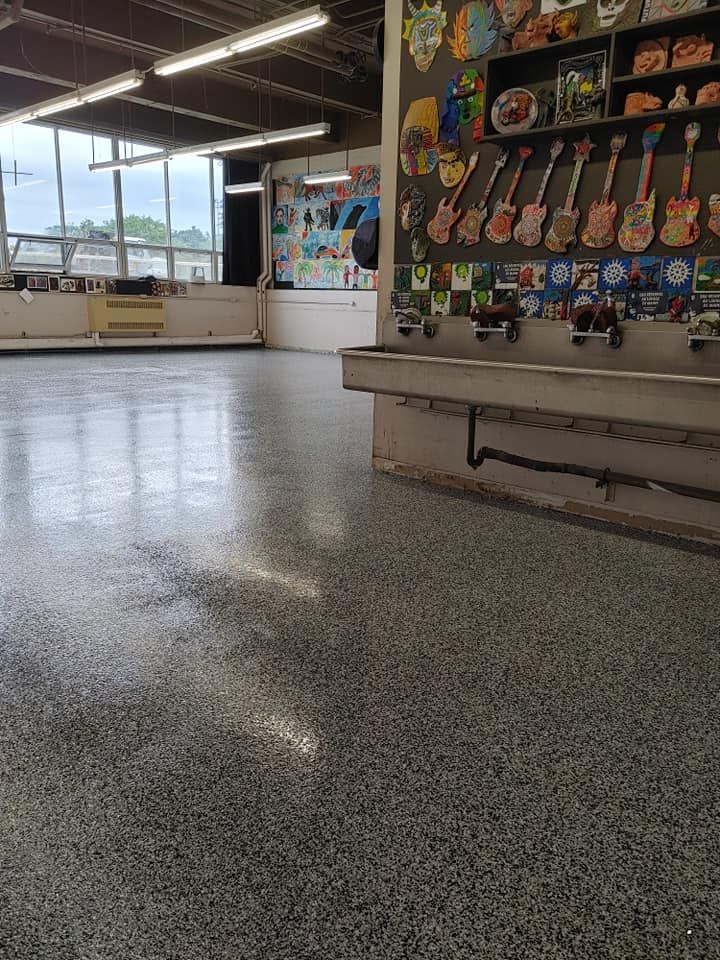 Une grande pièce avec un lavabo et un mur avec des guitares dessus.