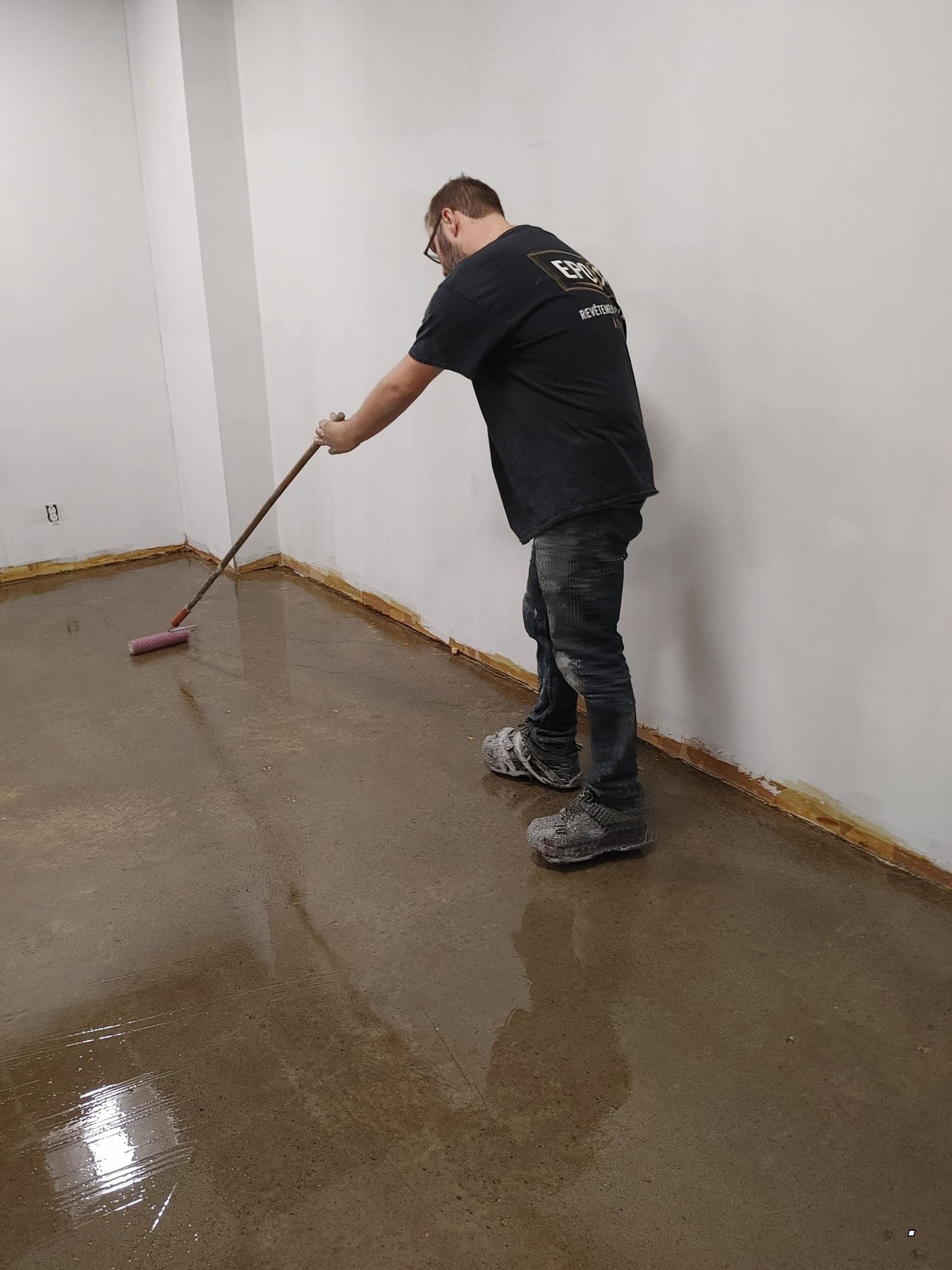 Un homme nettoie le sol avec un balai.
