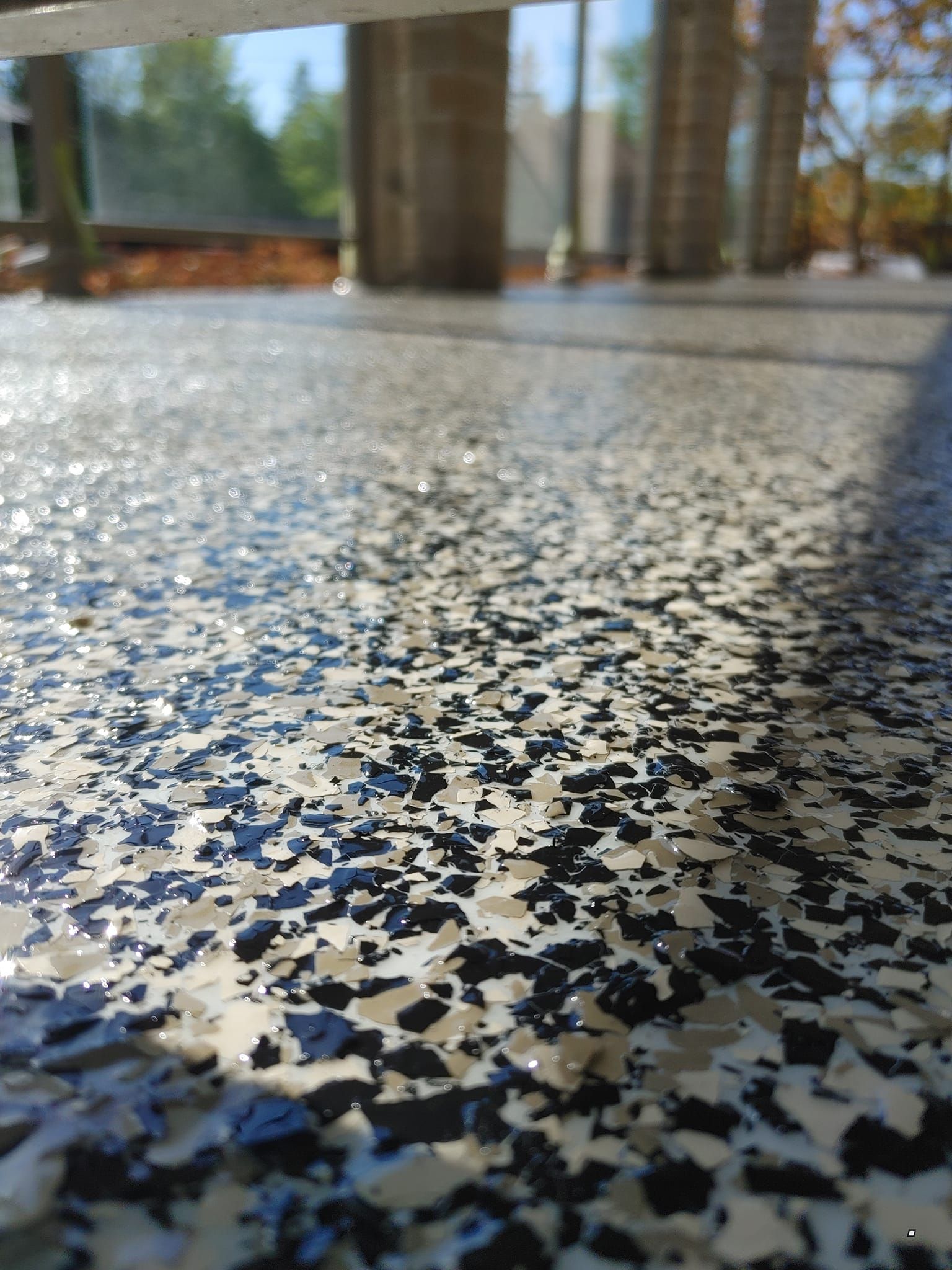 Un gros plan d'un sol en béton avec des flocons noirs et blancs dessus.