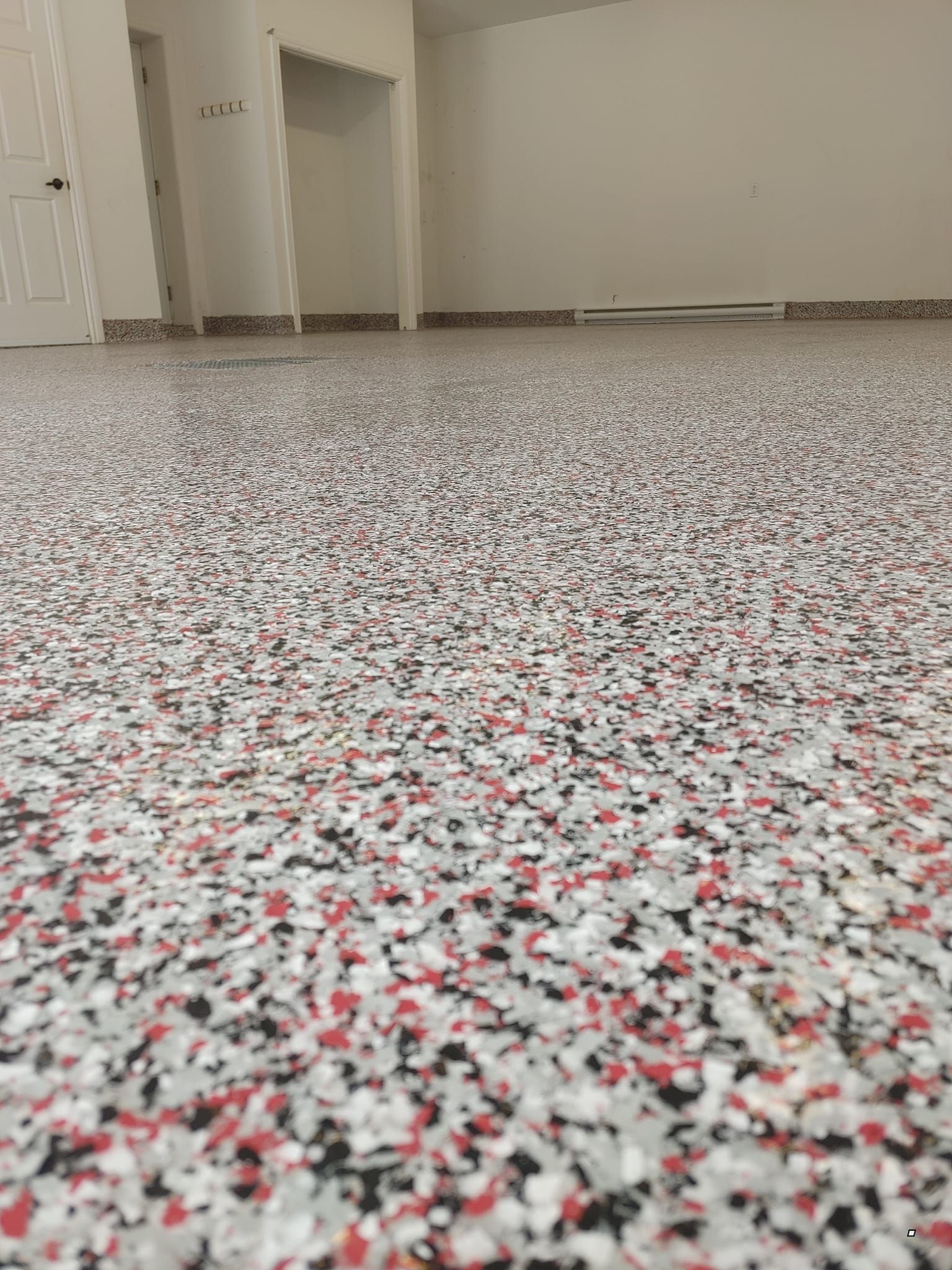 Un gros plan d'un sol rouge, blanc et noir dans un garage.