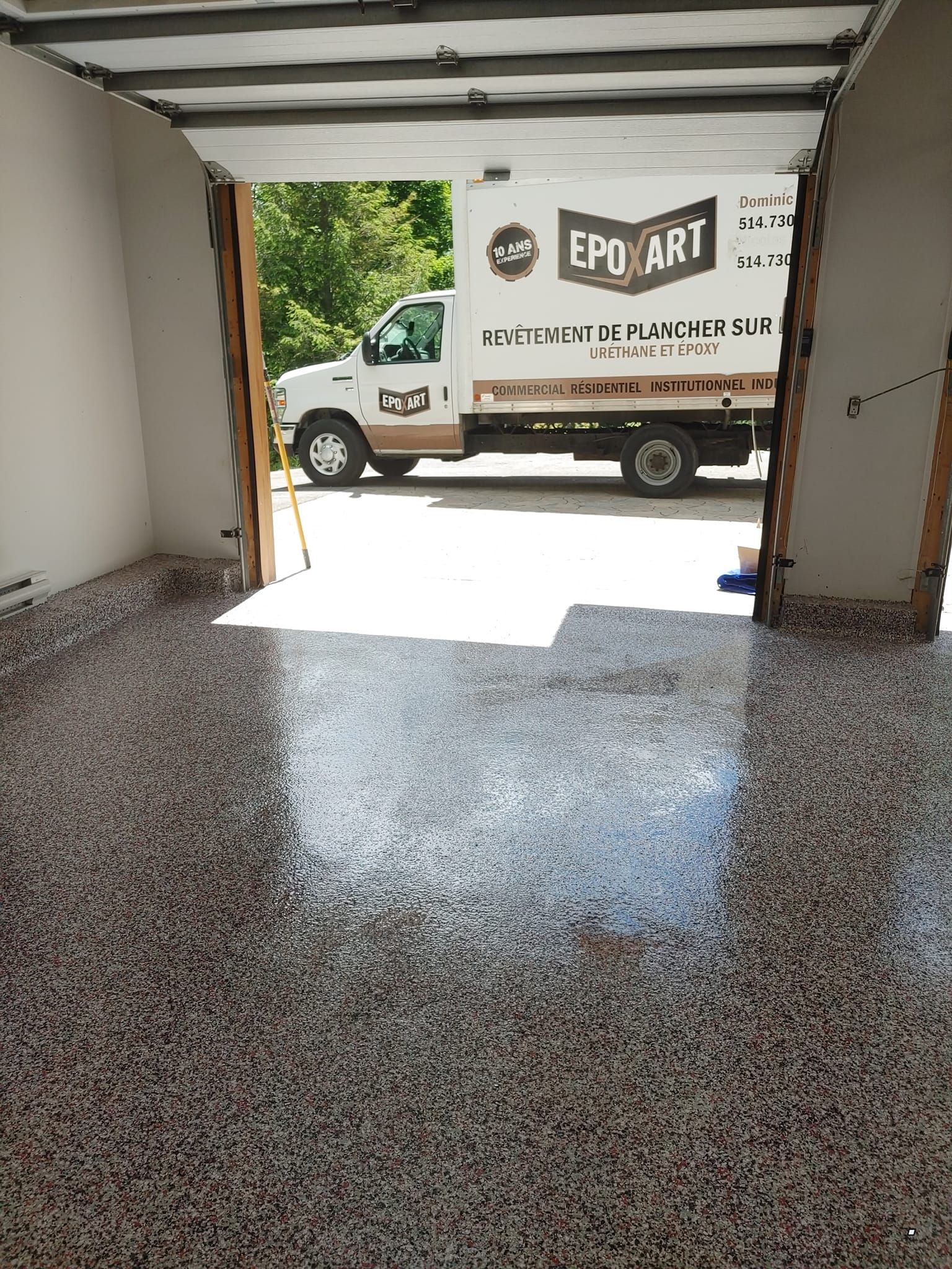 Un camion est garé dans un garage avec la porte ouverte.