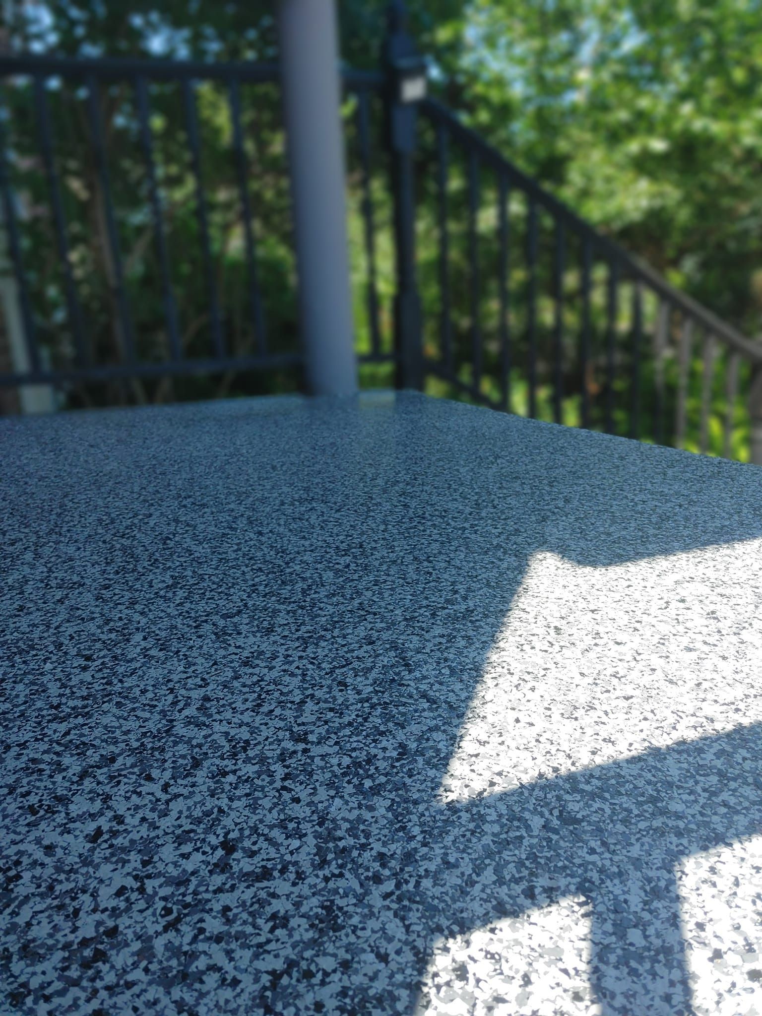 Un gros plan d'une terrasse avec une clôture en arrière-plan.