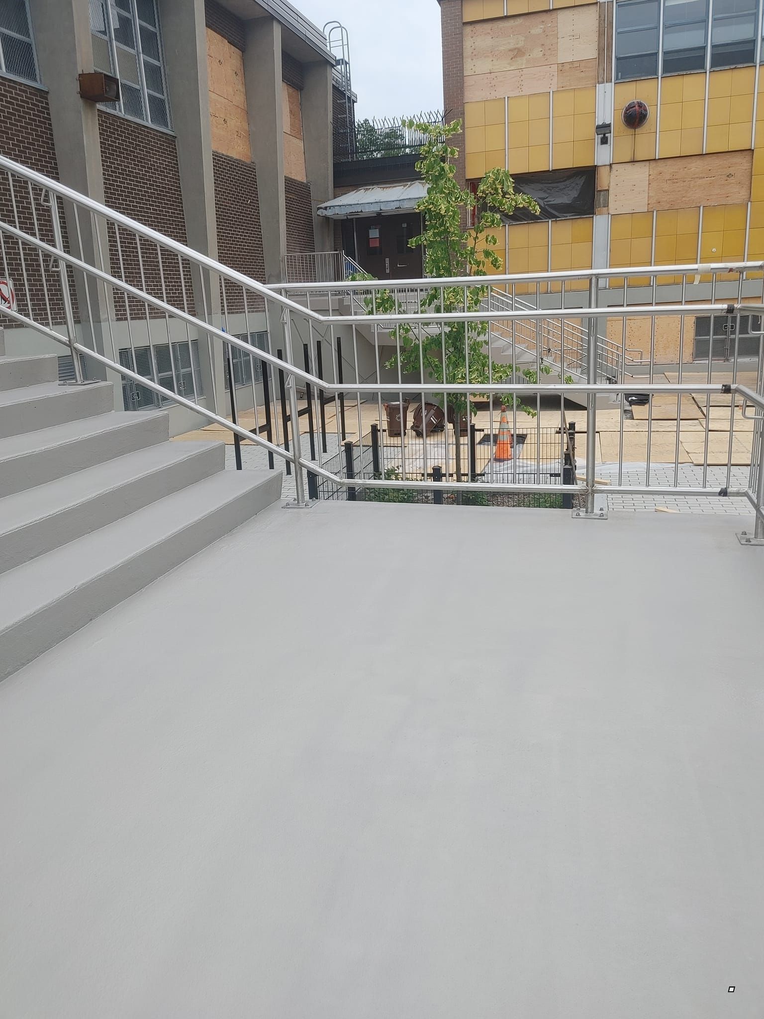 Un ensemble d'escaliers avec une rampe en métal et un bâtiment en arrière-plan.