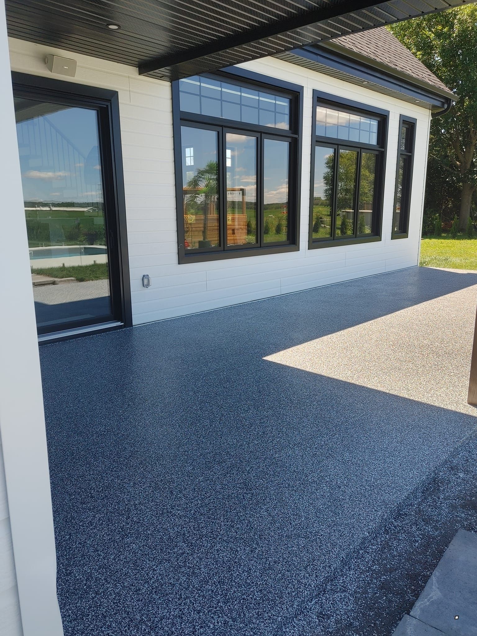 Un bâtiment blanc avec beaucoup de fenêtres et une allée de gravier devant.