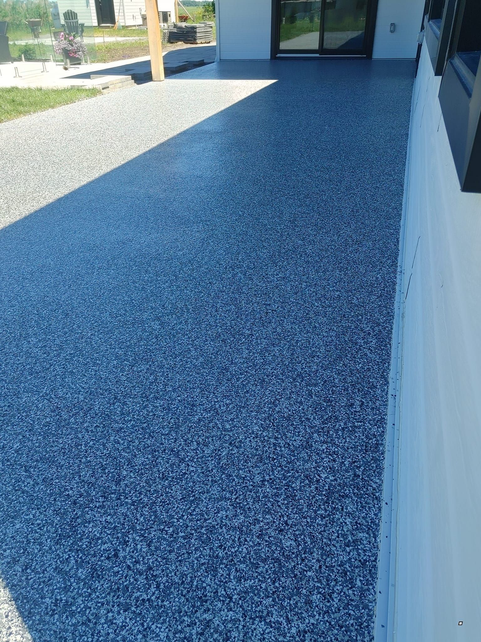 Une allée avec beaucoup de gravier et un mur blanc.