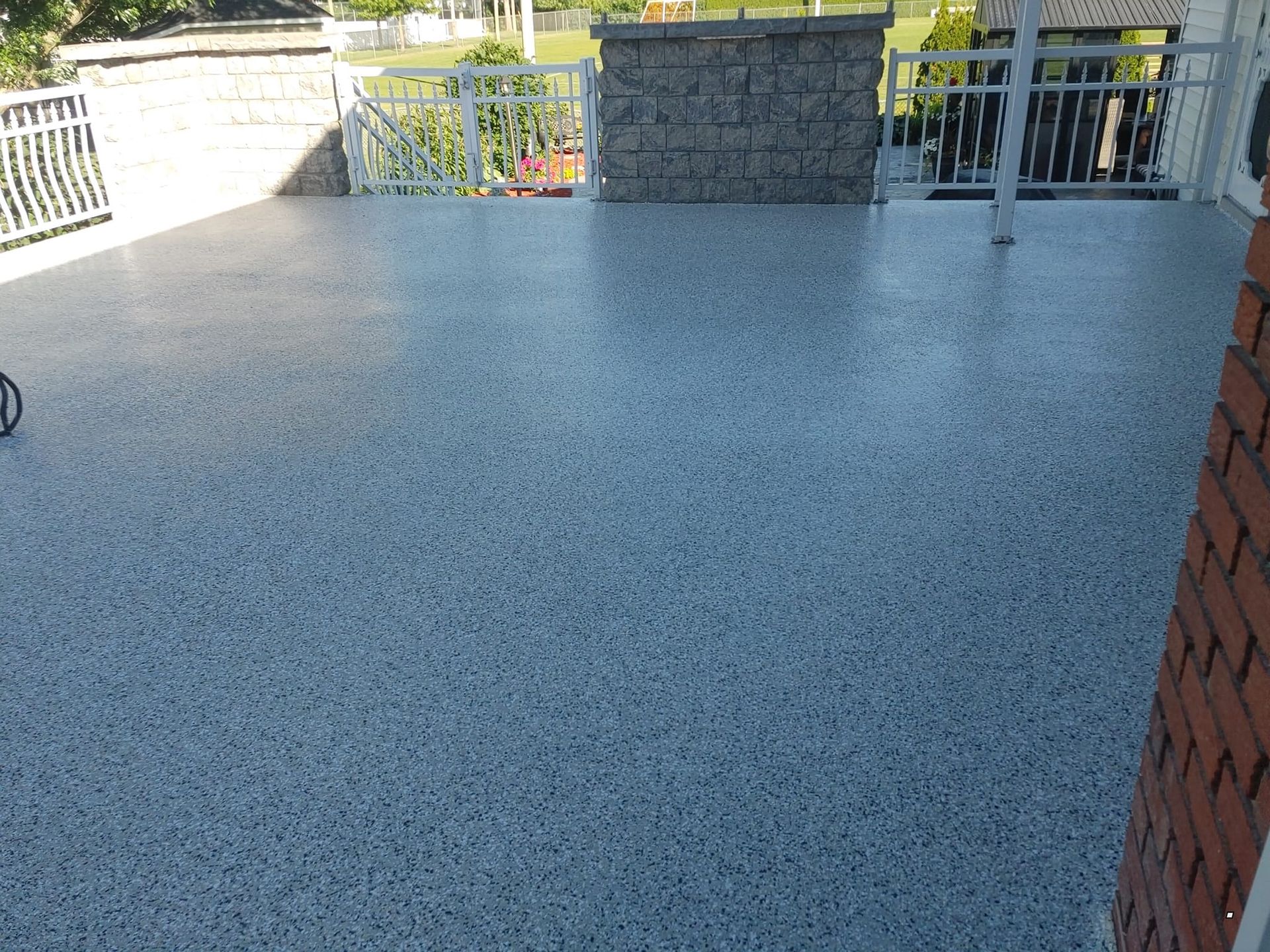 Un patio avec un sol en béton et un mur en briques.