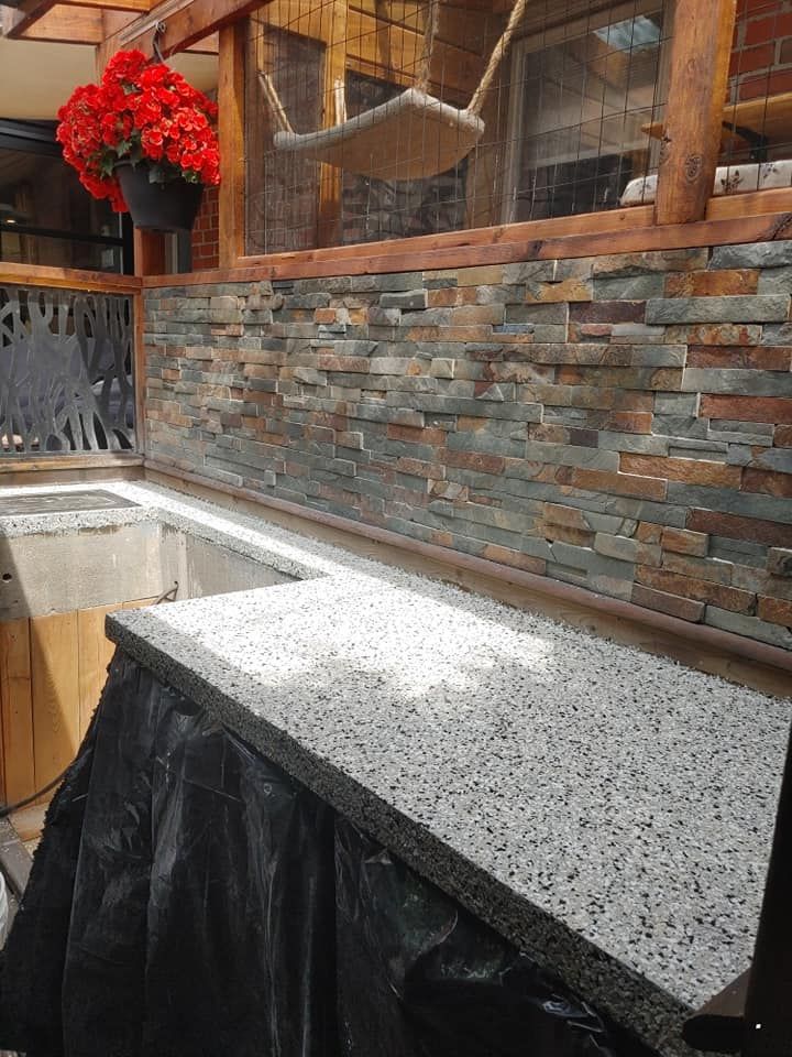 Un comptoir de cuisine avec un mur de pierre derrière.