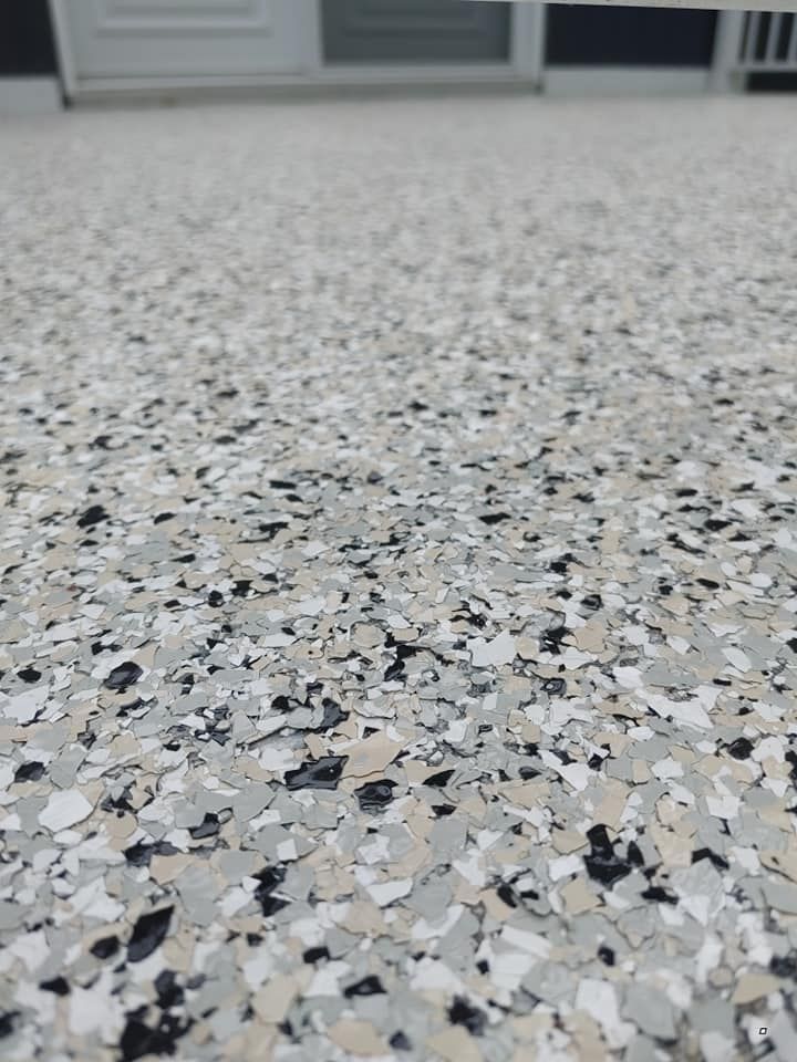 Un gros plan d'un sol en béton avec des flocons noirs et blancs.