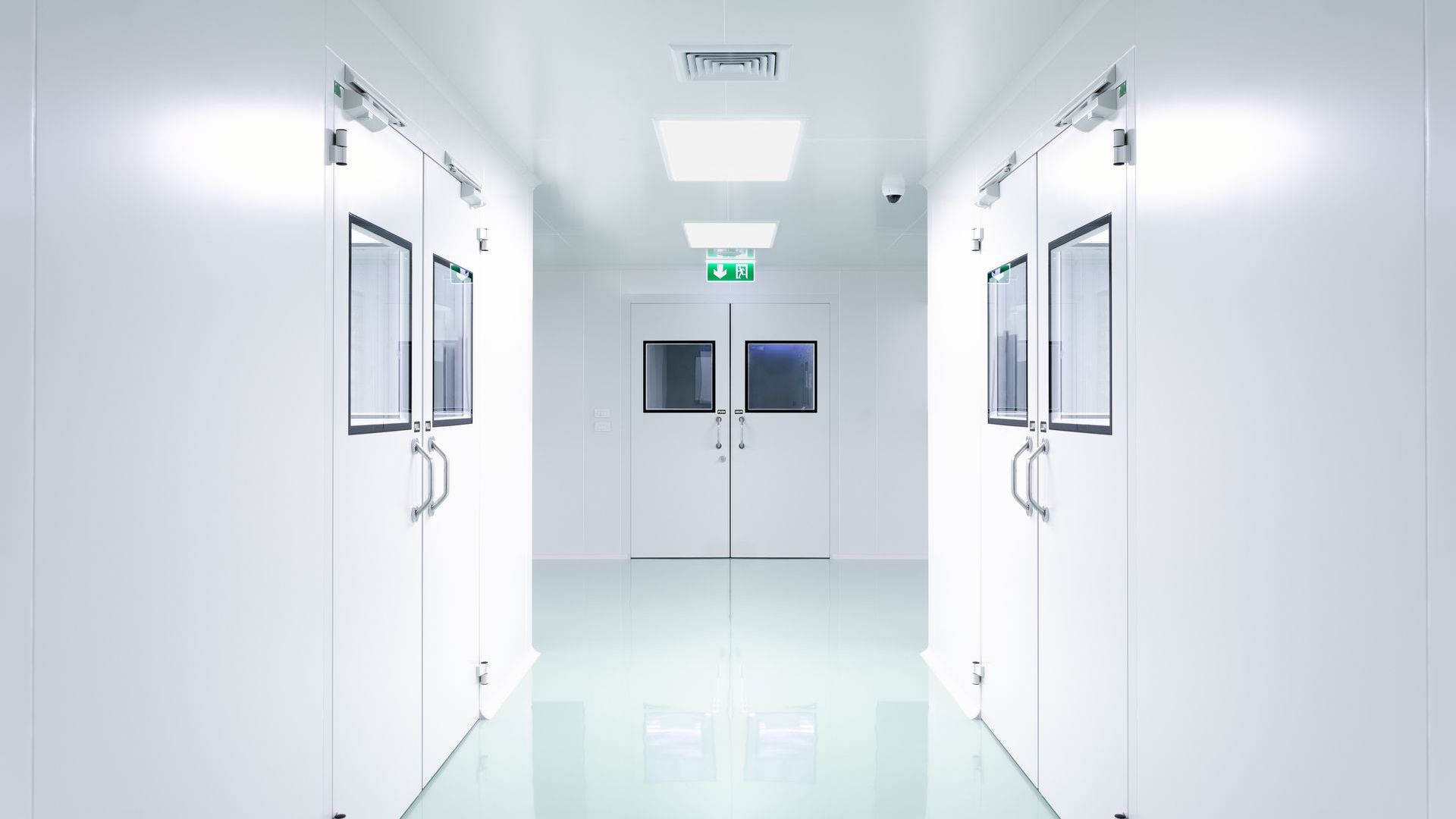 Un couloir dans une pièce propre avec des murs et des portes blancs.