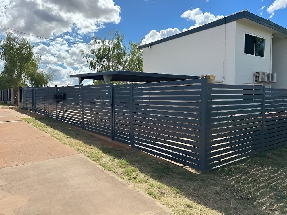 A Black Fence Is Surrounding A White House With Aluminum Slat — PH Davie in Mount Isa, QLD