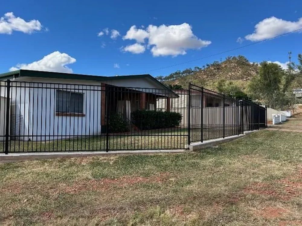 A White House With A Black Fence In Front Of It — PH Davie in Mount Isa, QLD