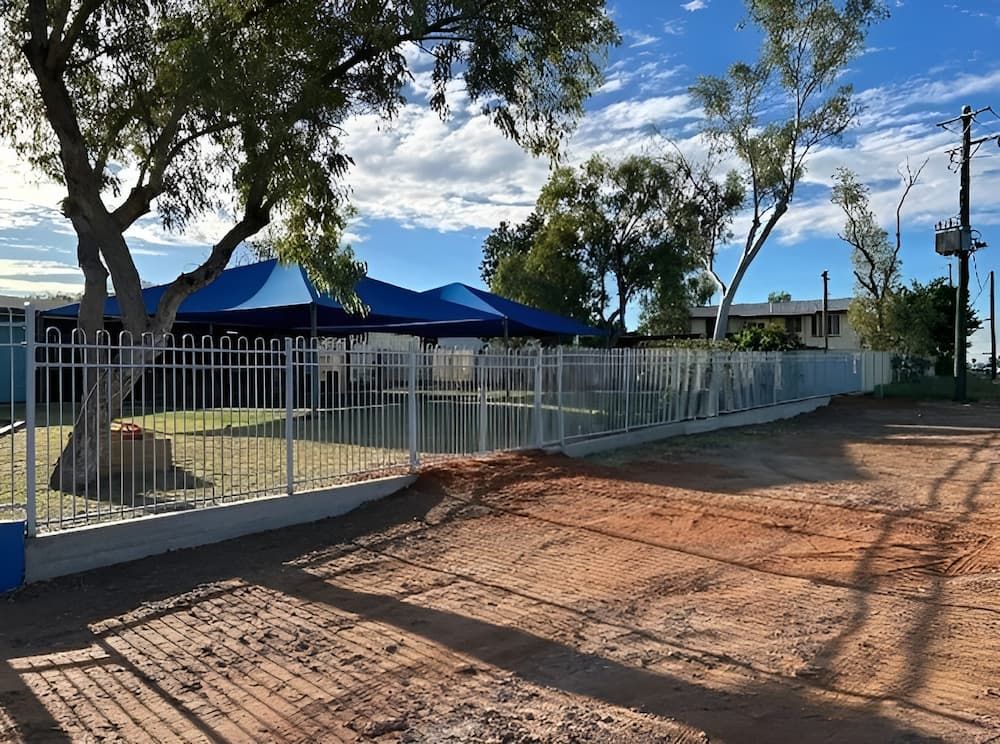 A Fence Surrounds A Dirt Road In Front Of A Building — PH Davie in Camooweal, QLD