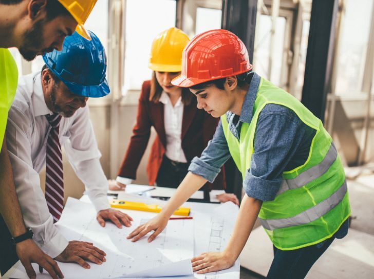 Un groupe de technicien réuni autour d'un plan de construction