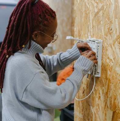 Photo d'une alternante de la filière Télécoms en train de s'entraine sur de câble