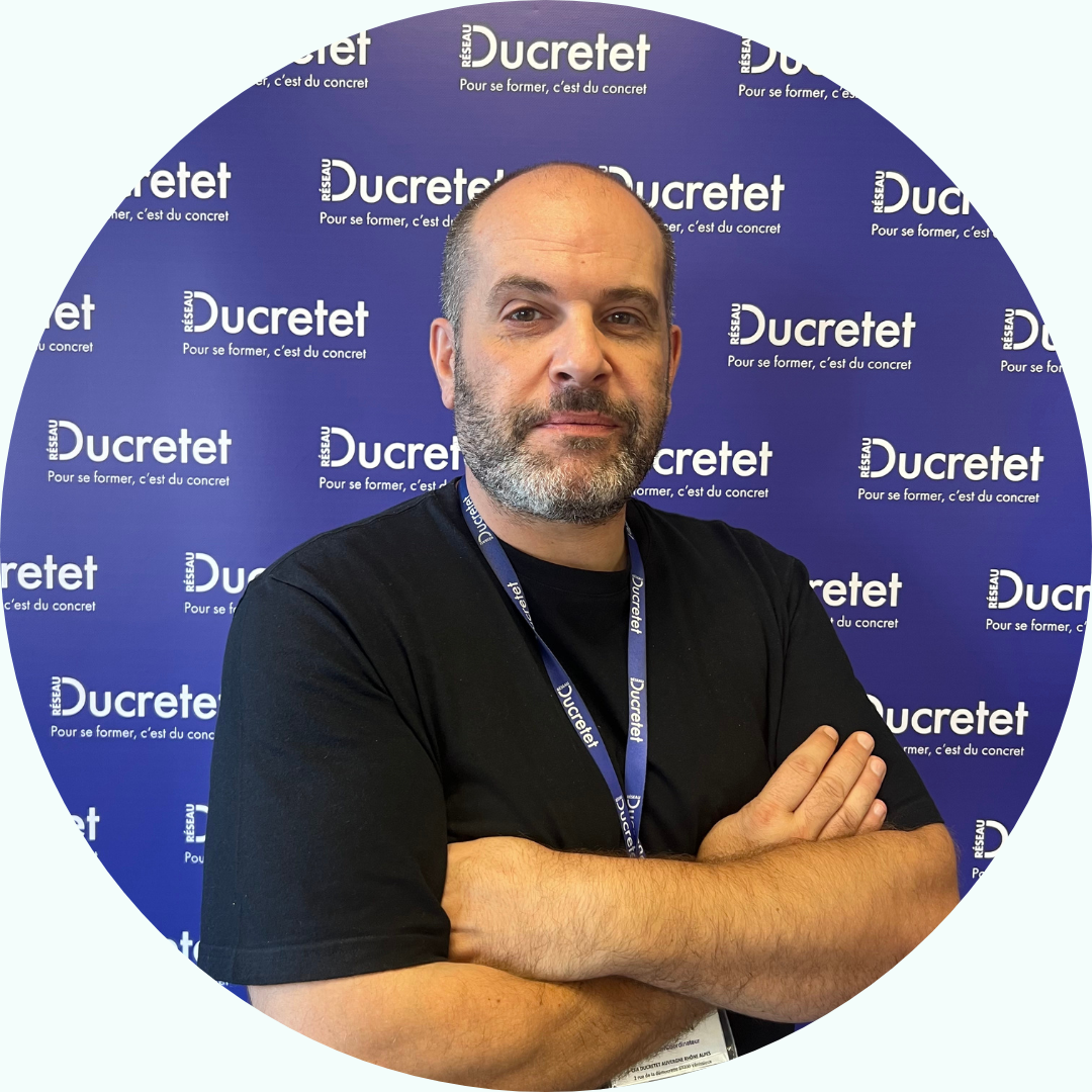 Homme aux bras croisés devant un décor 