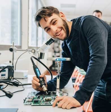 Photo d'un apprenant en train de réparer une machine connectée
