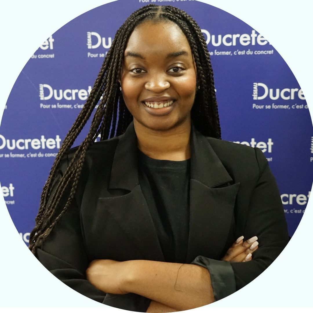 Femme aux cheveux tressés, souriante, les bras croisés, devant un fond bleu avec du texte.