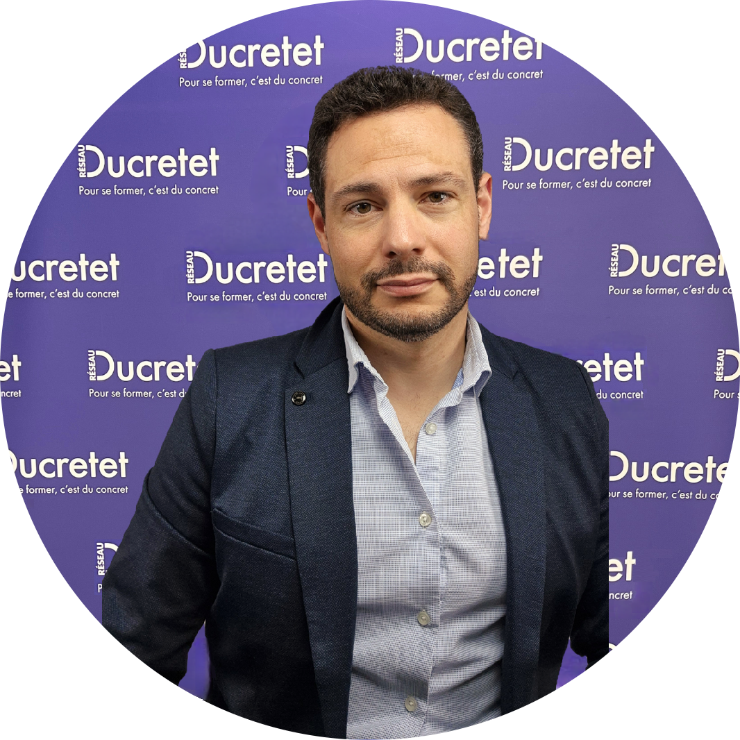 Homme en blazer et chemise ouverte, posant devant un fond avec des logos 