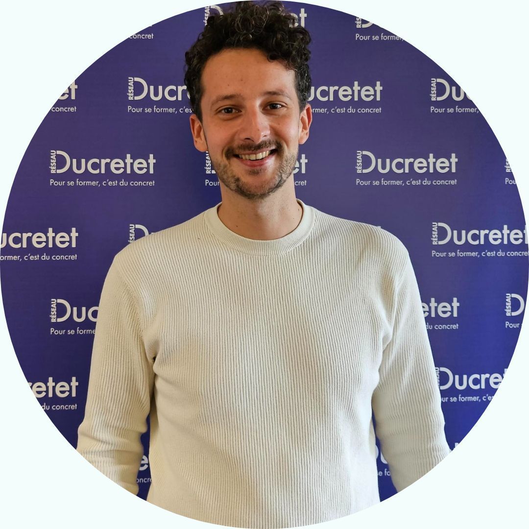 Homme souriant en pull blanc, sur fond avec le logo 