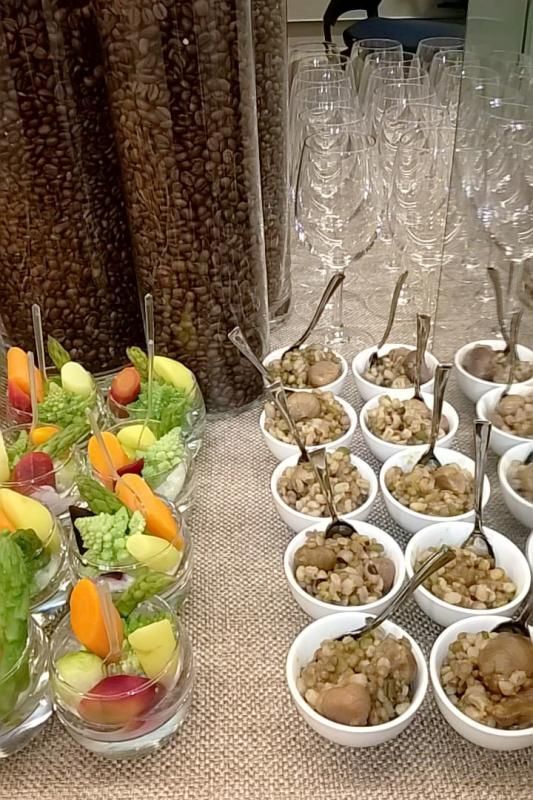 Un tavolo sormontato da ciotole di cibo e bicchieri di vino.