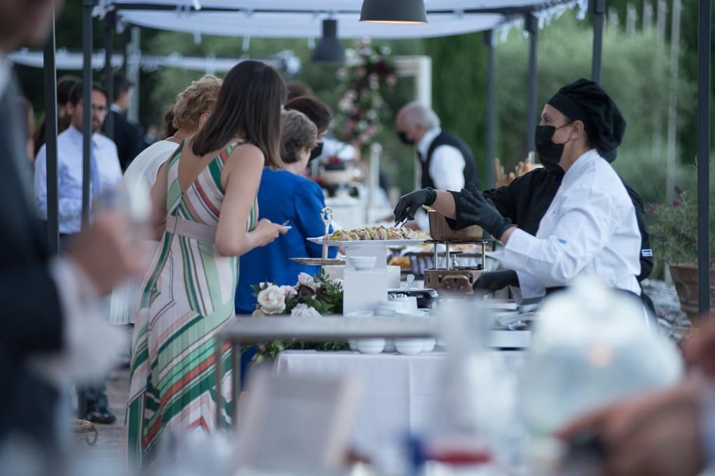 Un gruppo di persone è in piedi attorno a un tavolo davanti a un buffet.