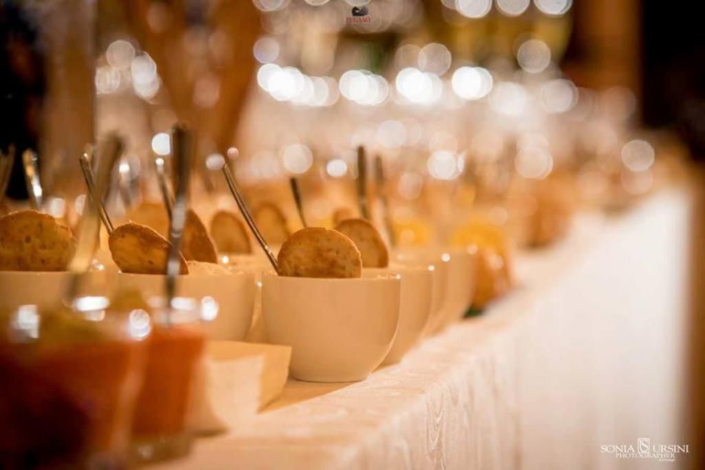 Un lungo tavolo sormontato da ciotole di cibo e cucchiai.