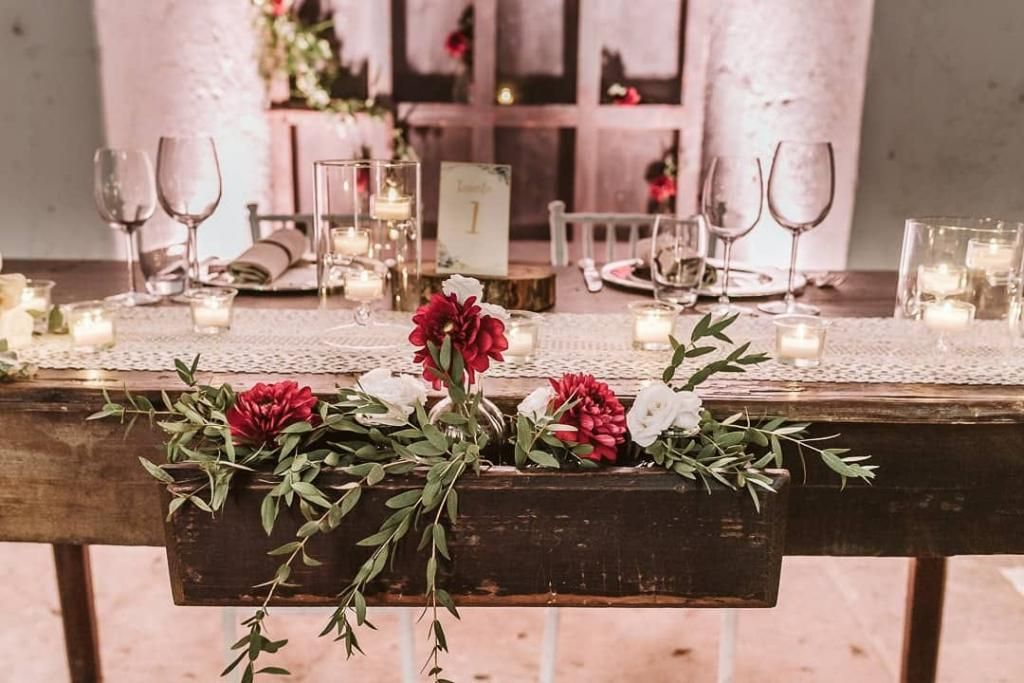 Un tavolo di legno con fiori e candele sopra.